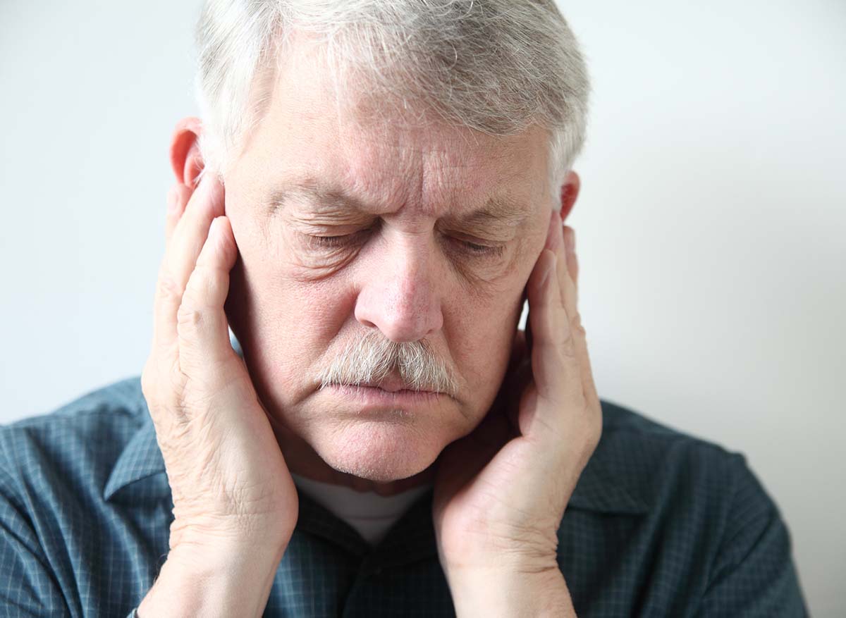 Senior man suffering from temporomandibular joint (TMJ) pain