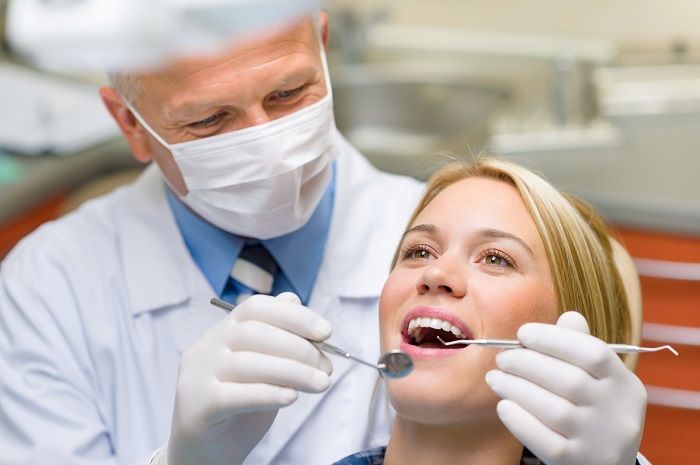 dentist doing quality control on dental crown