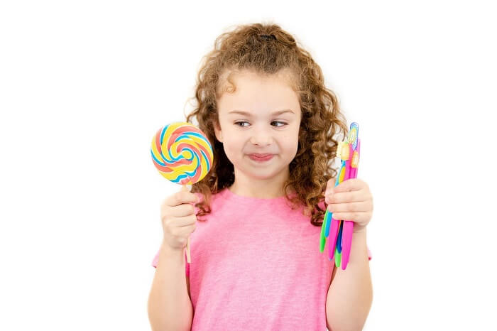 girl with lollipop and toothbrush
